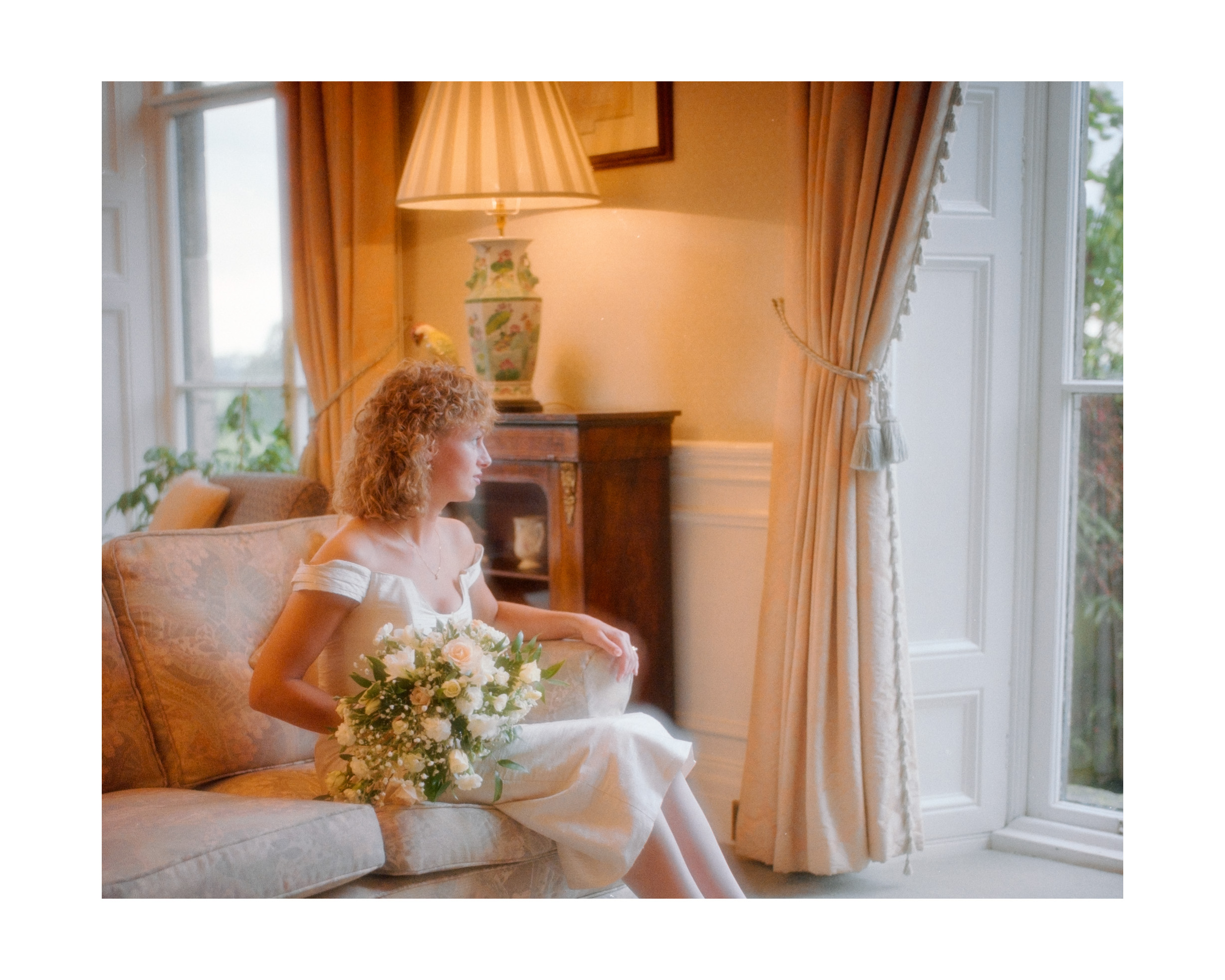 Wedding Photographer in Dorset – Dave Broomfield - Image of Bride at home looking through window.