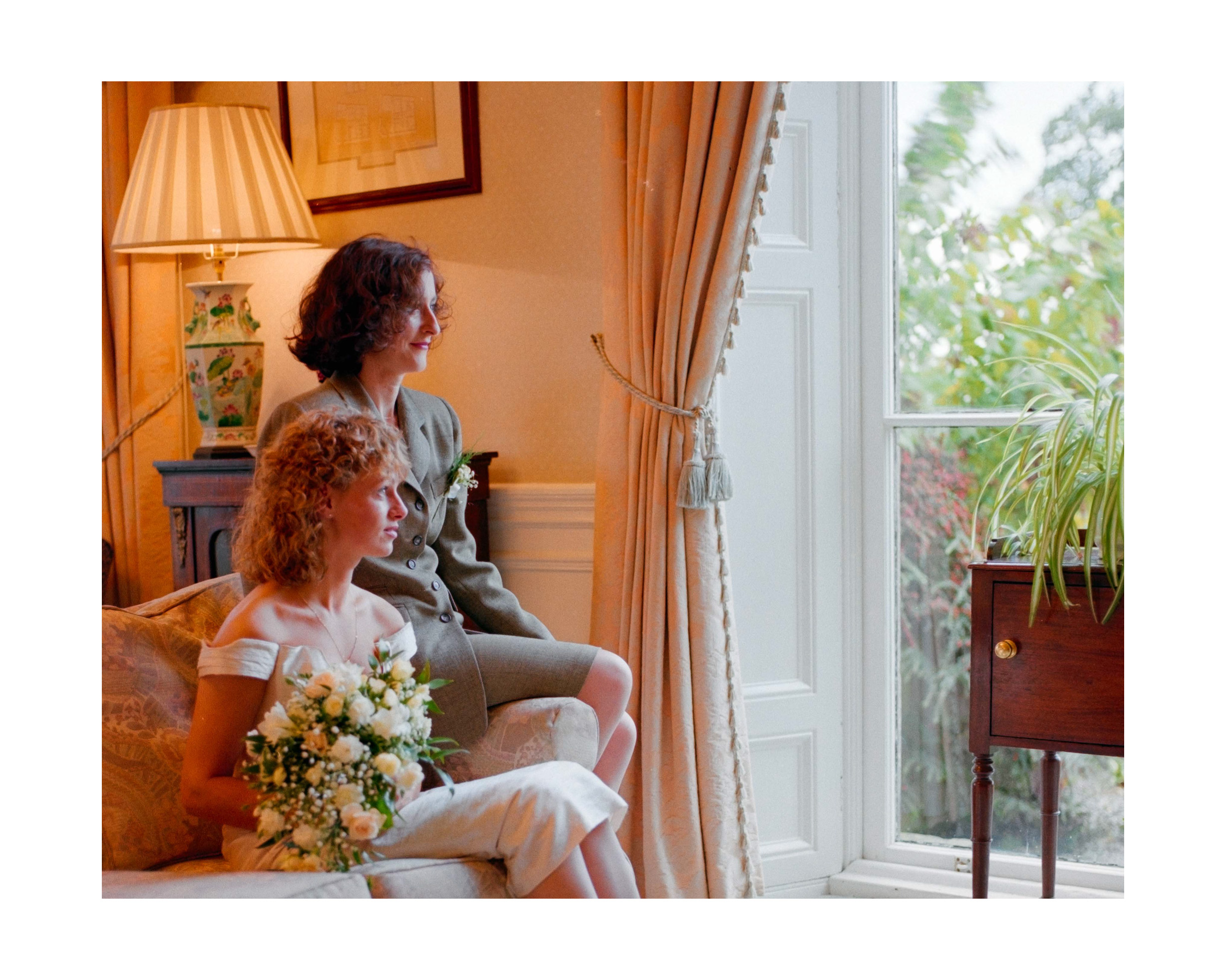 Dorset Wedding Photographer – Image of Bride and Bridesmaid by window